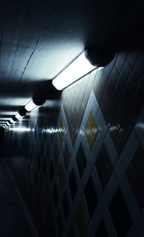 light streaming in between two tiled rooms of an empty subway