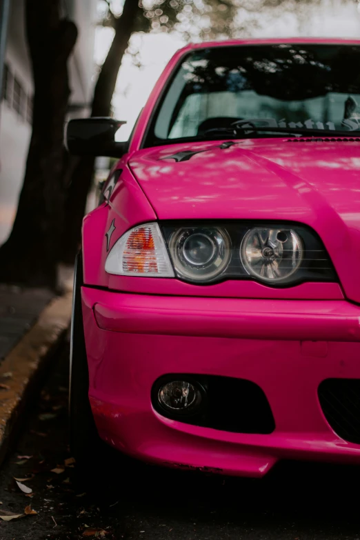 a pink car is parked on a street