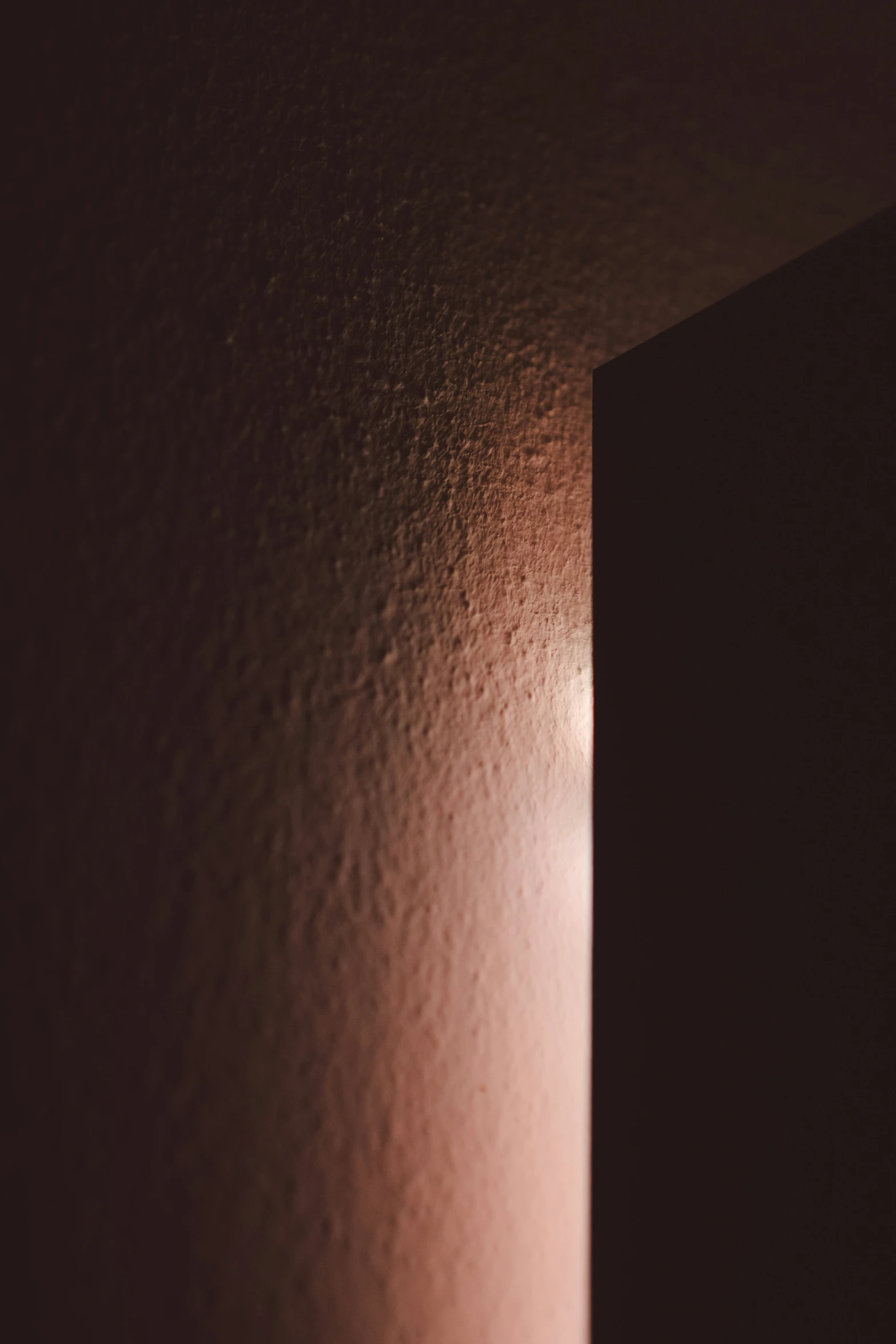 a po of the dark side of a wall with light streaming through