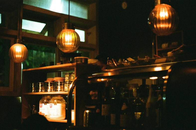 several hanging lights and hanging jars on the wall