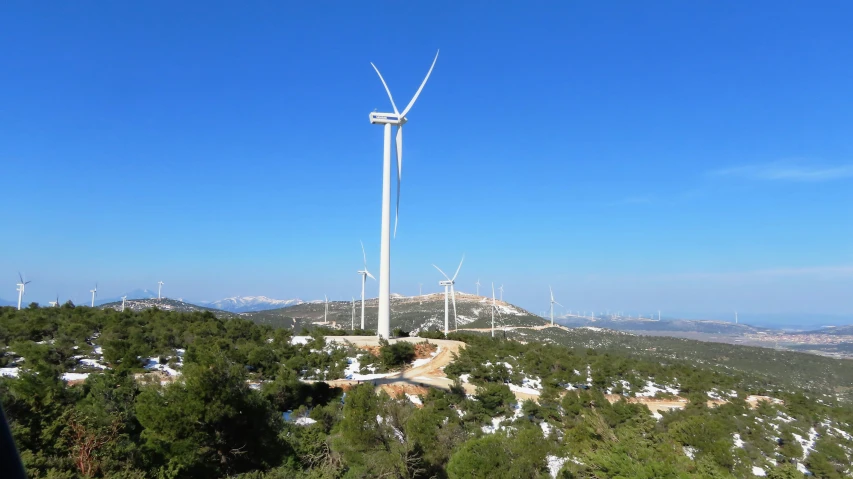 a wind turbine on top of a large hill