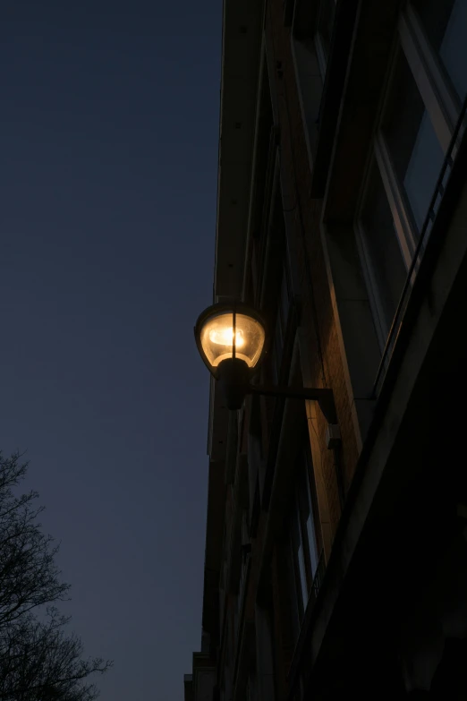 an old lamp lit up at night in the city