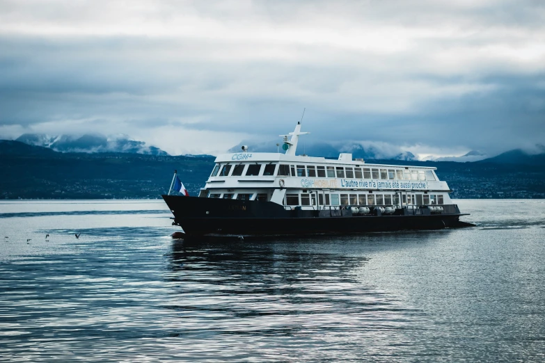 a large boat is in the ocean near mountains