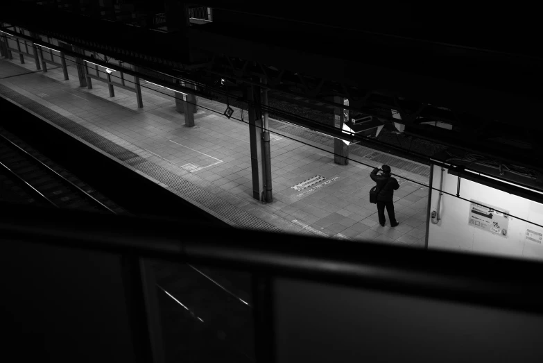 a person on a subway platform with other people standing on the platform