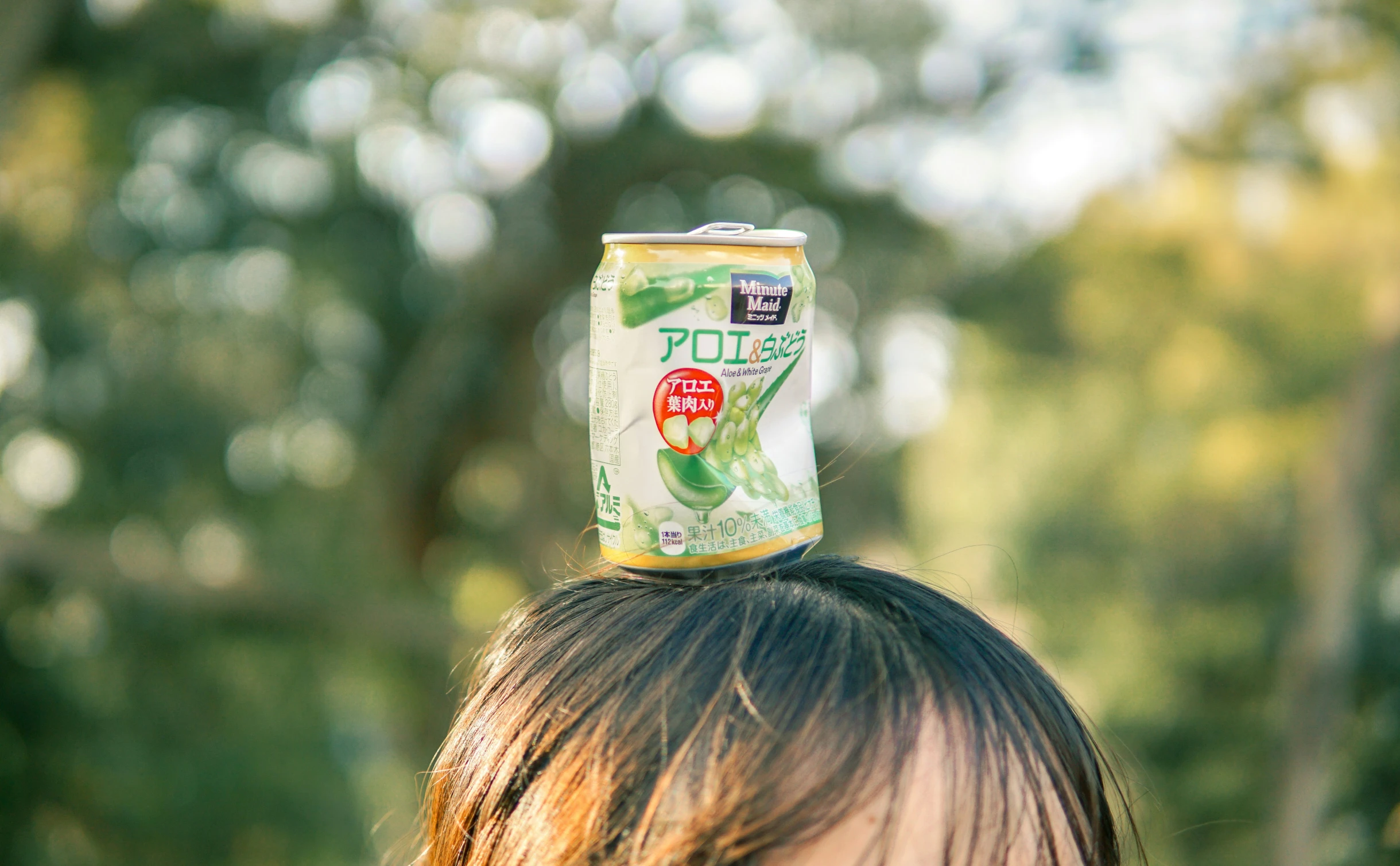 a little girl standing with a can on top of her head