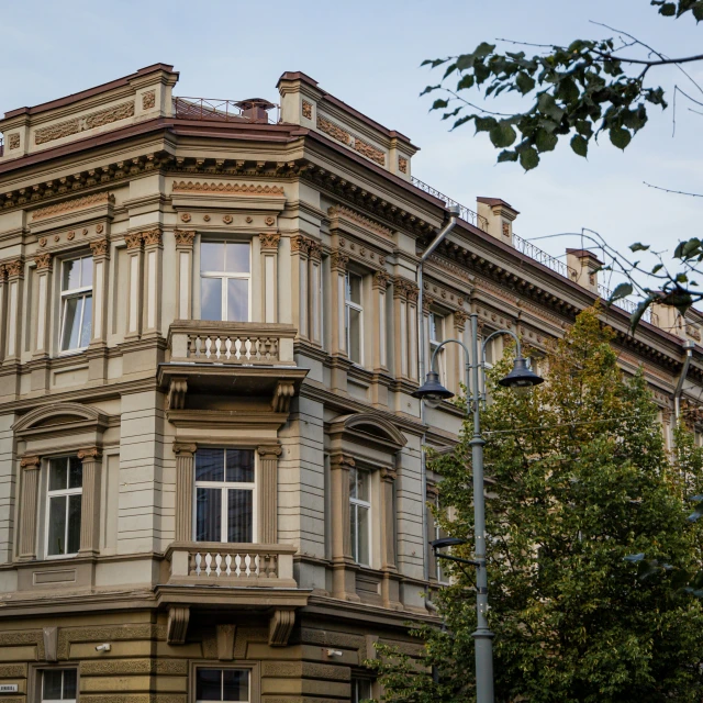 a street corner with a large building in the foreground and trees