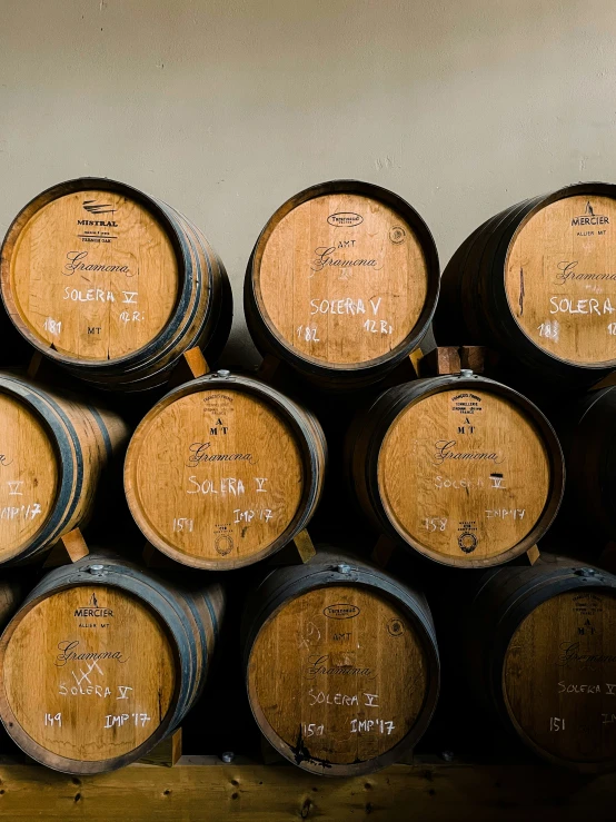 several wood casks stacked up on a shelf