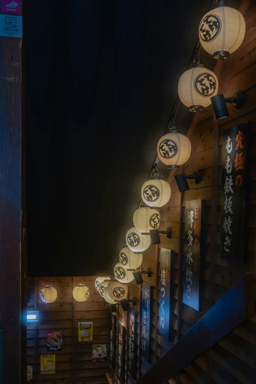 lanterns hanging from an indoor ceiling covered in chinese characters