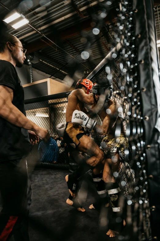 two men standing together in a cage