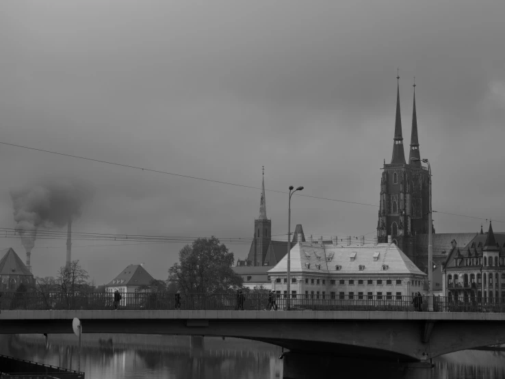 black and white pograph of an old bridge with castle in the background