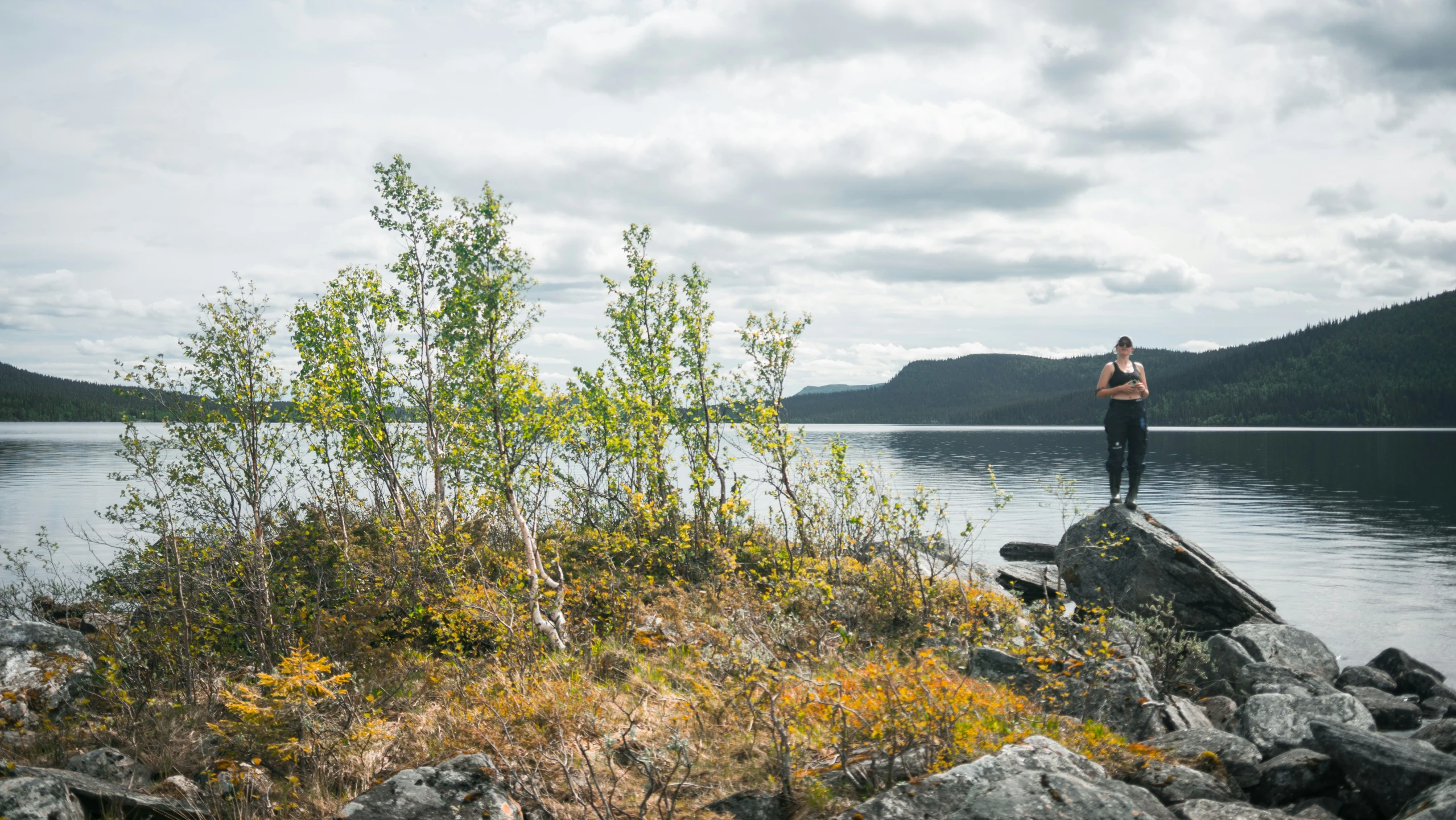 the man is standing on the rocks in the water