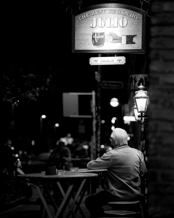 a man sitting at a table in front of a restaurant