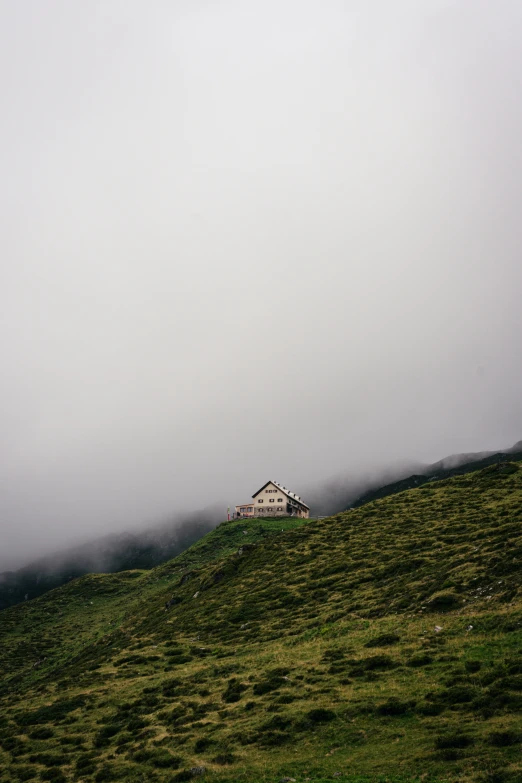 a lone house perched on top of a mountain