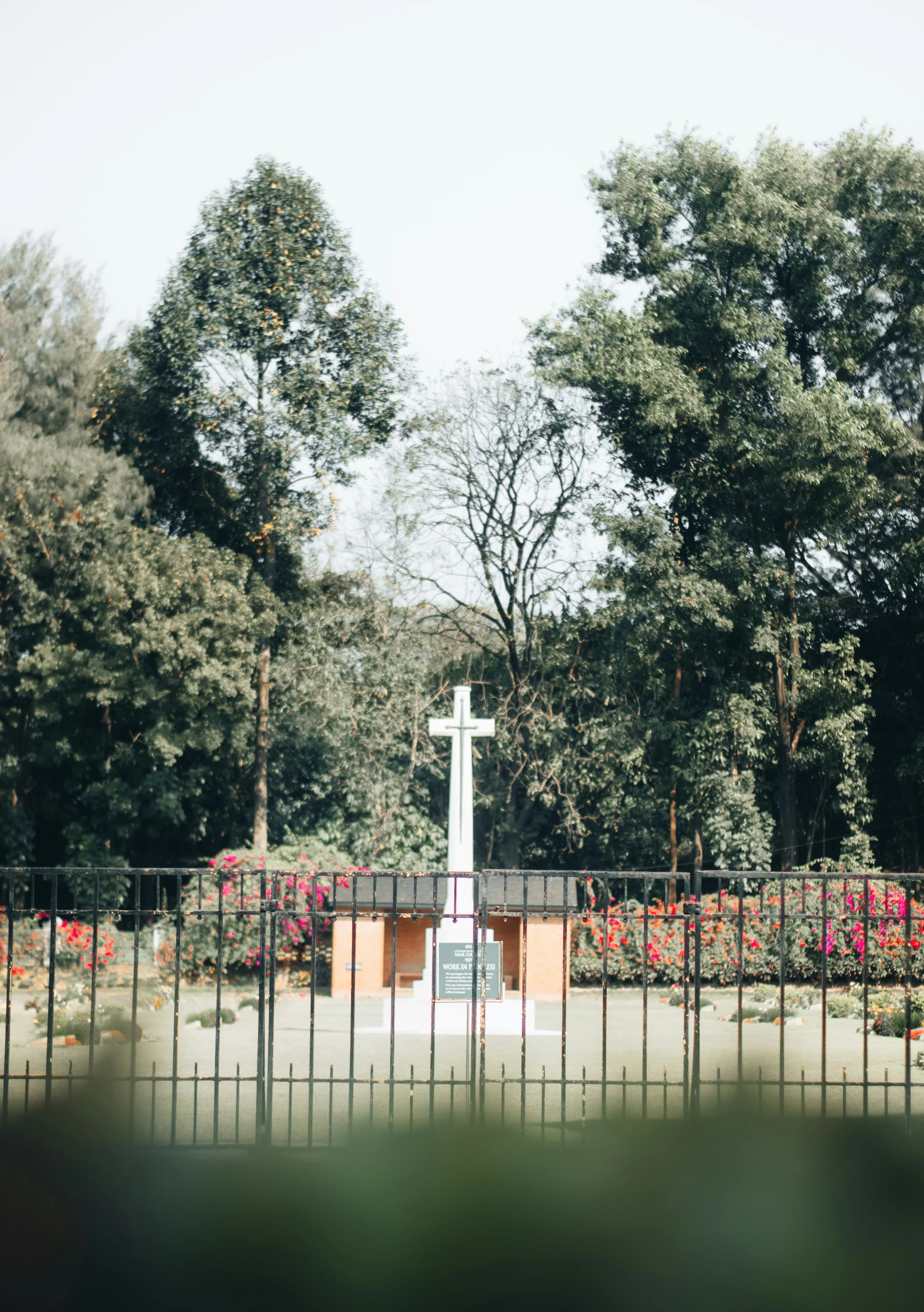 a white cross is standing at the base of a statue