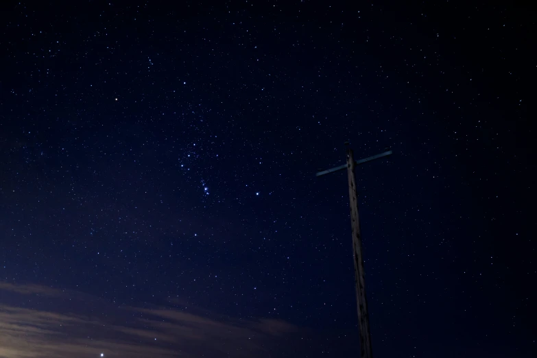 a dark sky with white stars and dark street lights