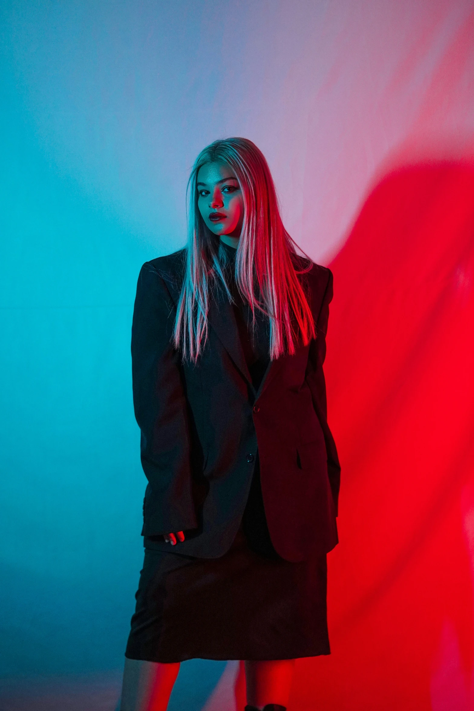 a woman posing in front of a red and blue background