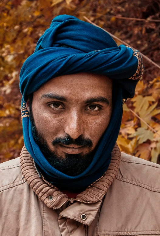 this is a man wearing a blue turban over his face