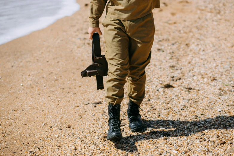 a man holding an umbrella standing on the beach