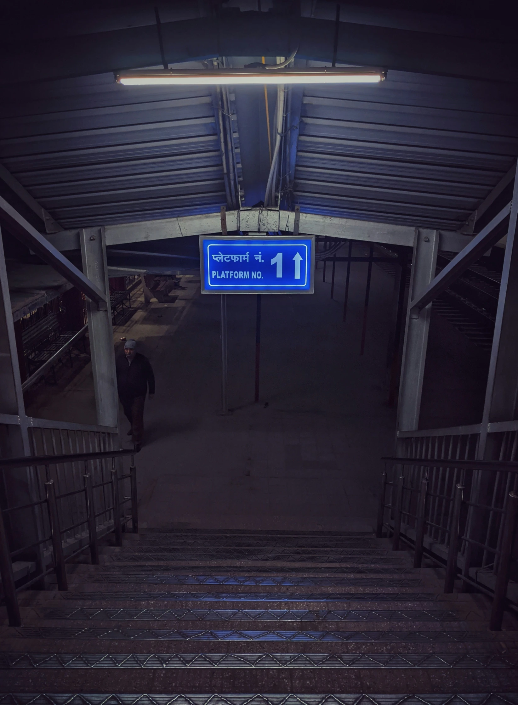 a blue street sign on a metal staircase