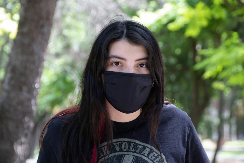 the woman wears a black mask to protect herself from the wind