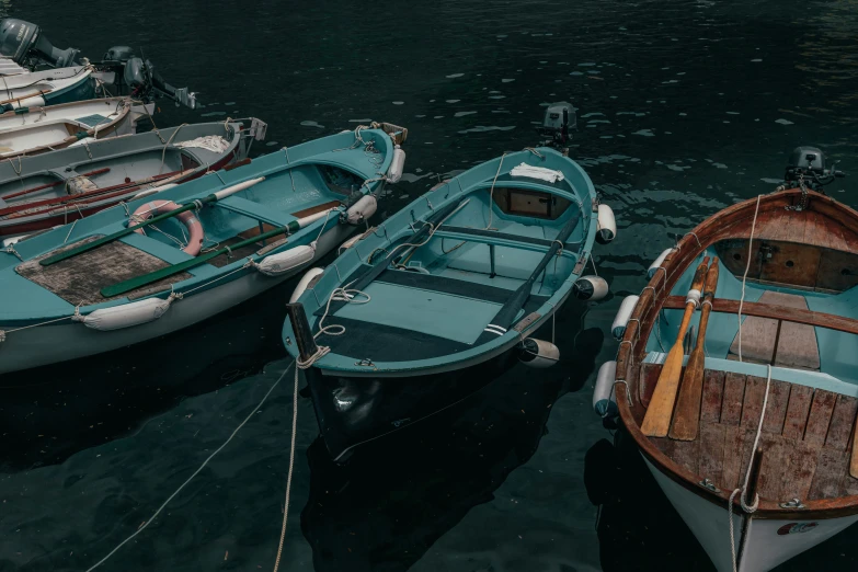 four small boats are tied together to the dock