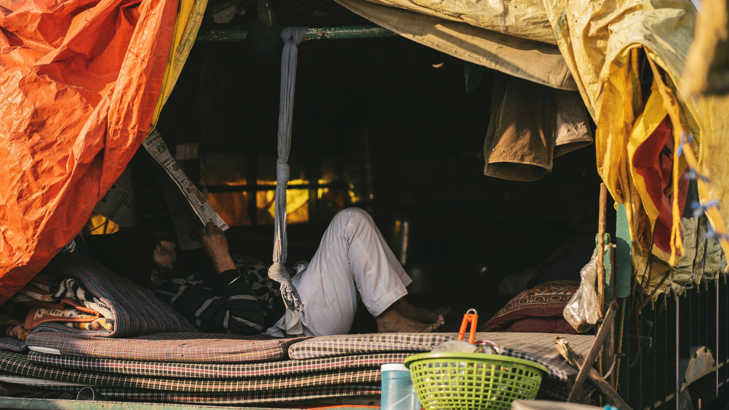 an outdoor tent with a person on top and a dog sitting on the ground