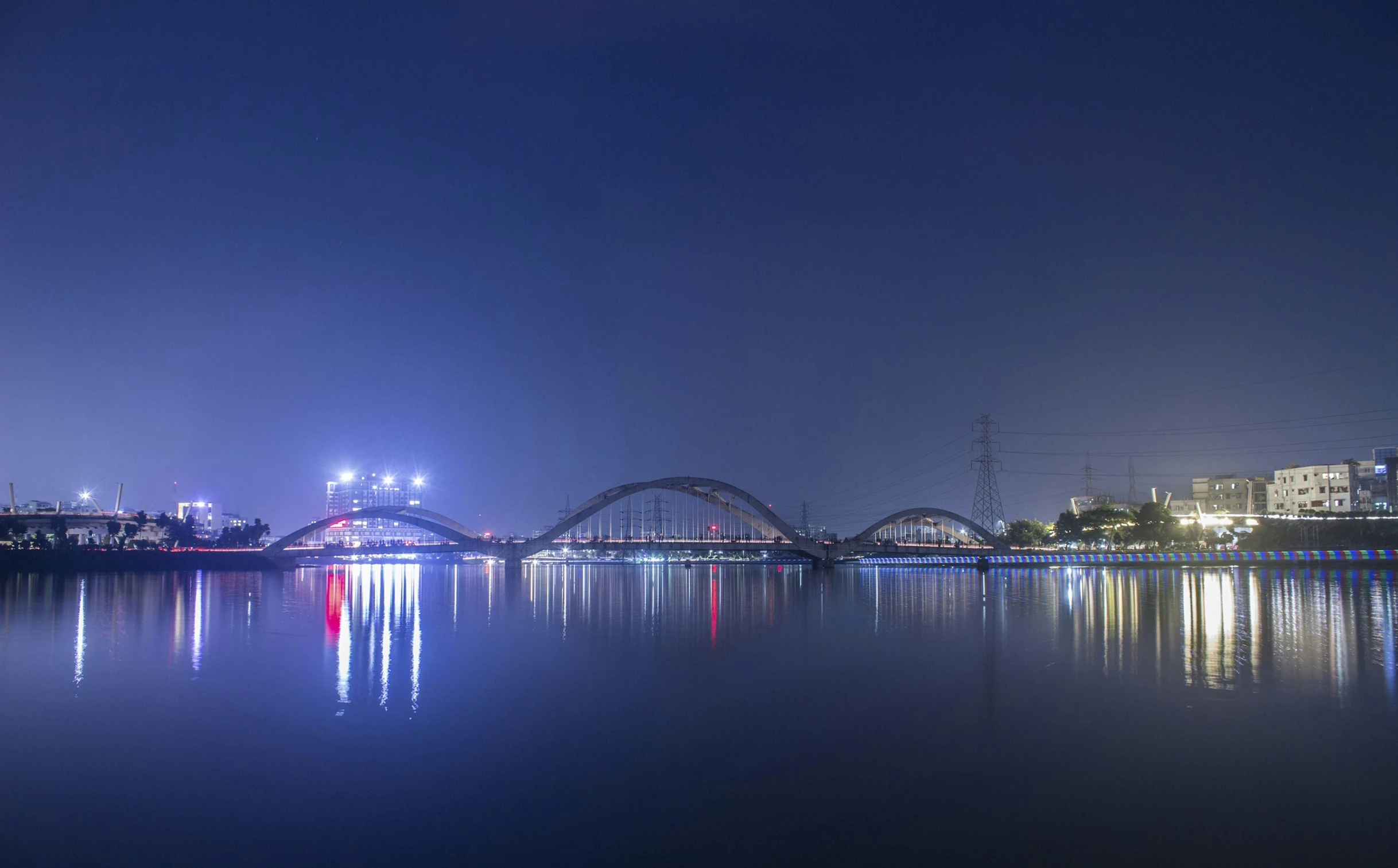 the view of a bridge over water with a city in the background