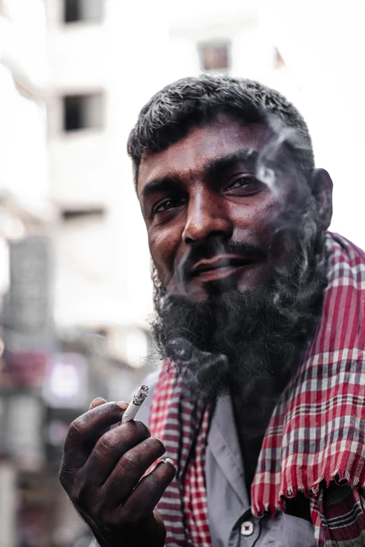 a man standing in the street smoking a cigarette