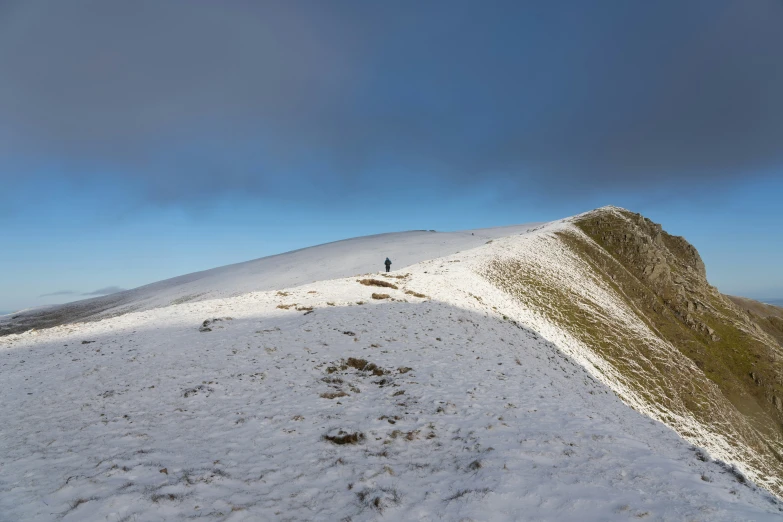 there is a man standing on a snowy hill