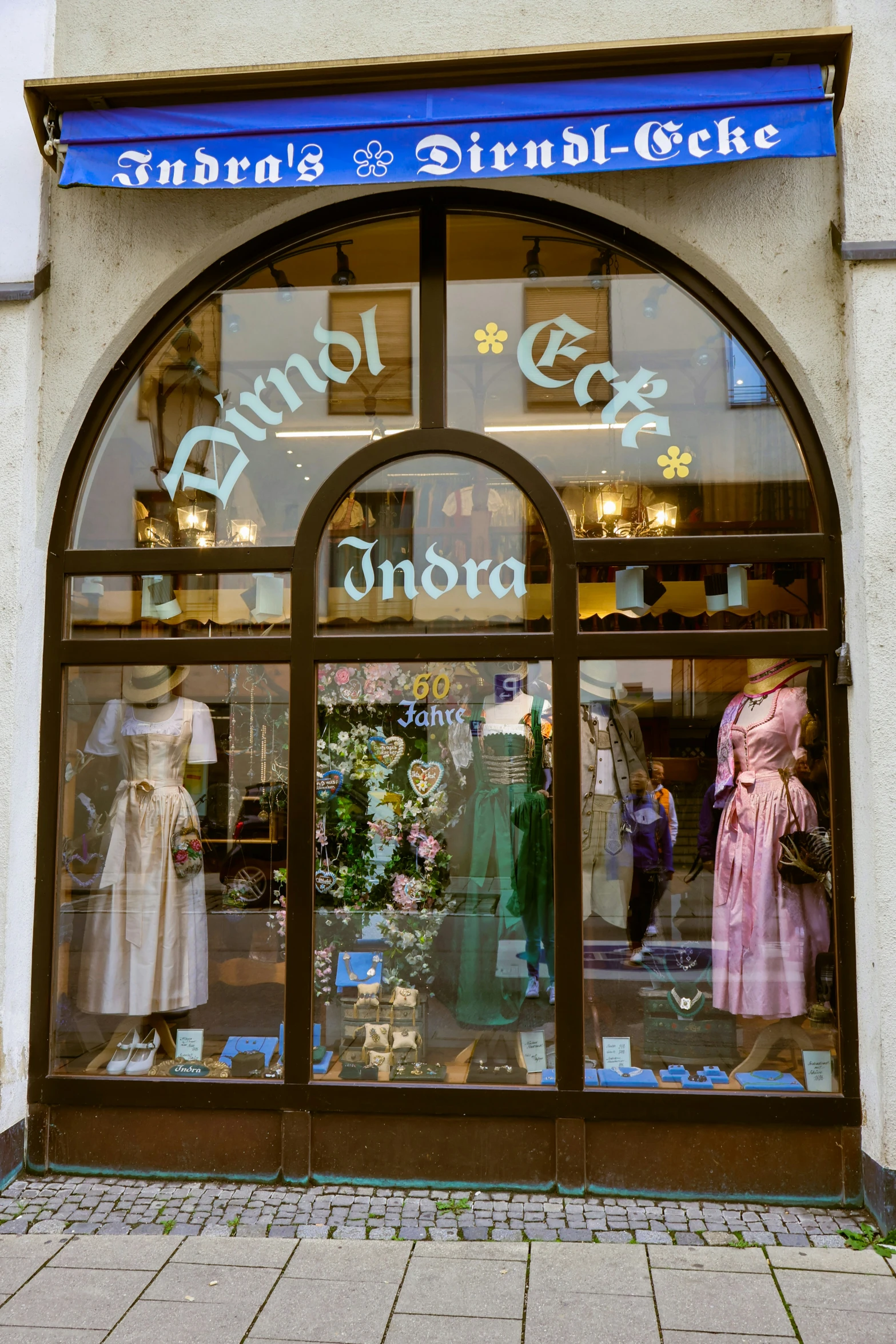 the front door of a retail store with two women's gowns in it