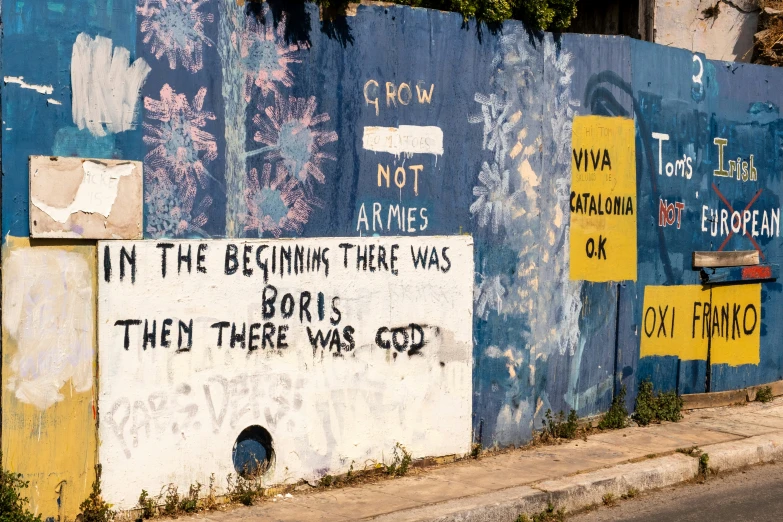 several signs on a blue wall with writing