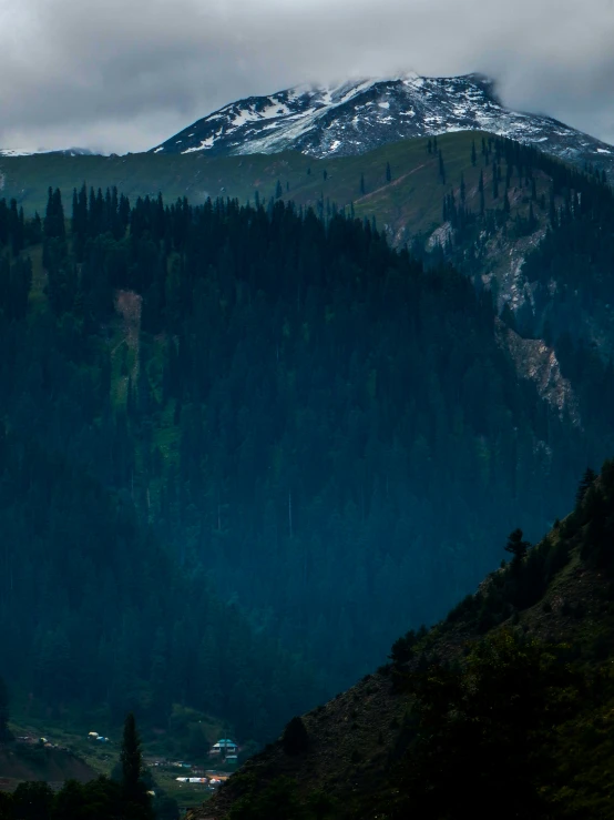 a very large mountain with some trees in the foreground