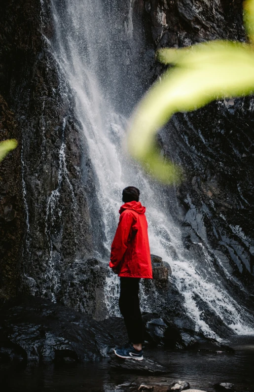 a man standing in front of a water fall