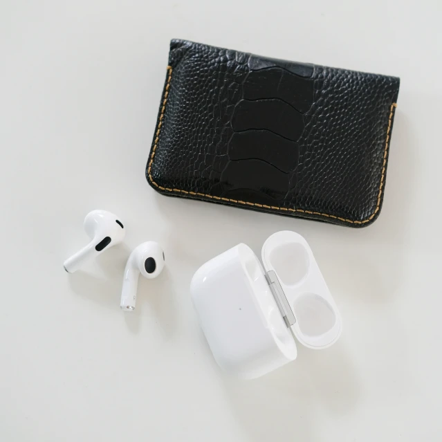 black case and two ear buds sitting on a white table