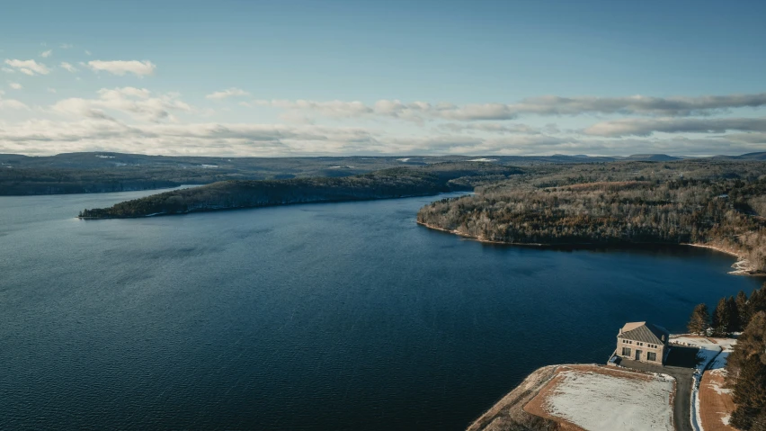 a body of water next to a forest filled hillside