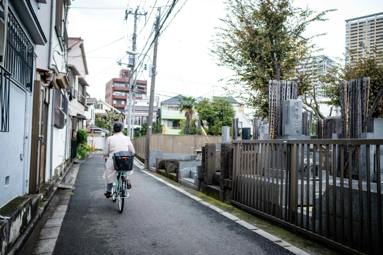 a woman riding a bicycle down an alley way