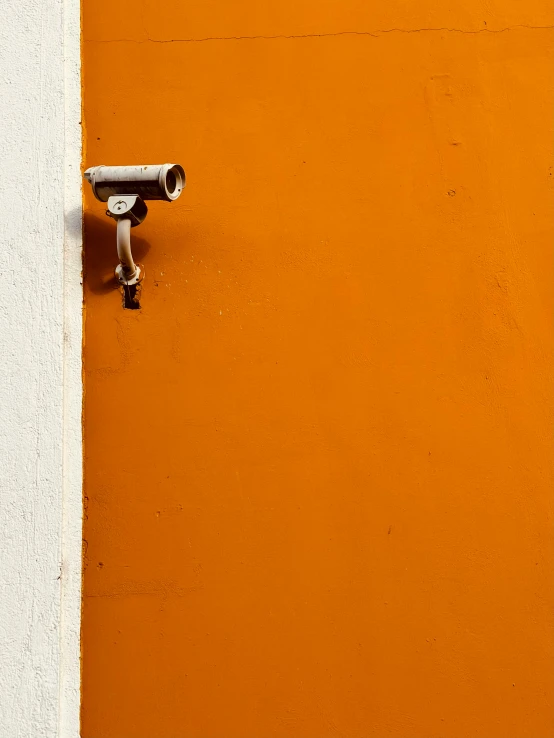 a security camera is on the side of a wall