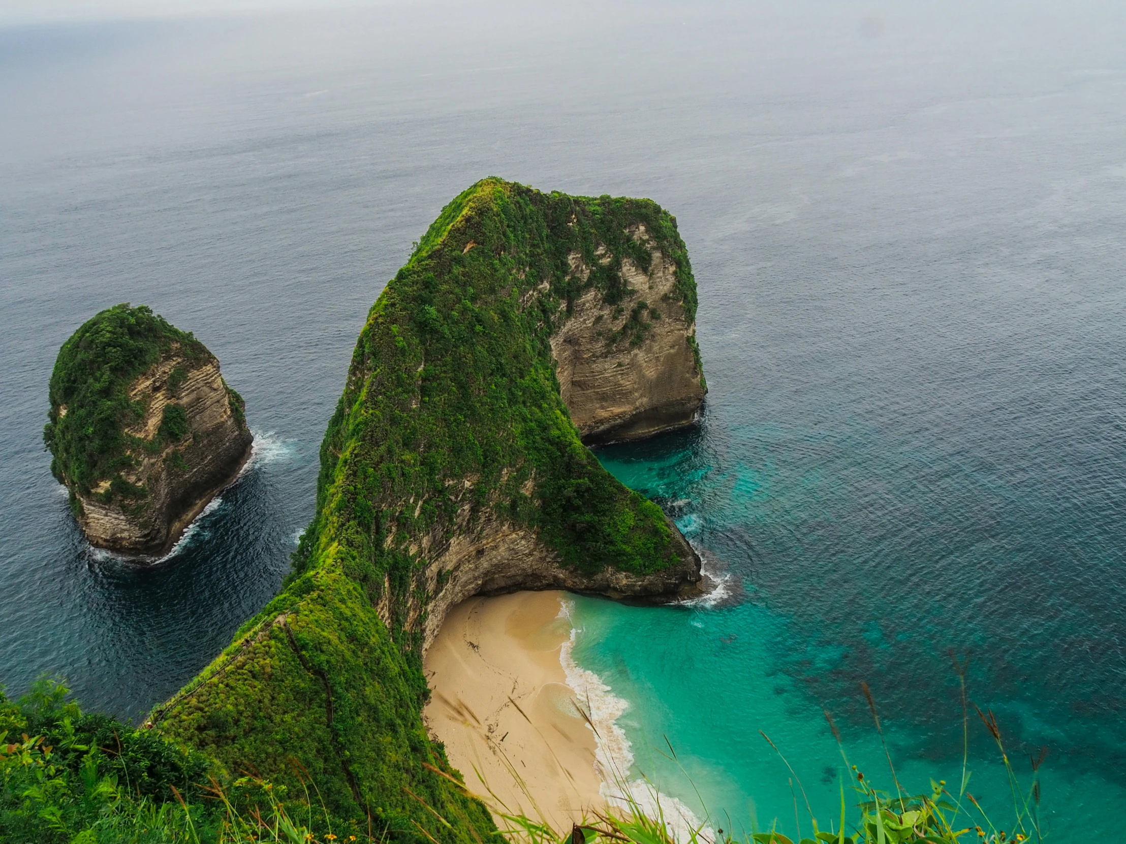 the two rock formations near the beach are shaped like heads