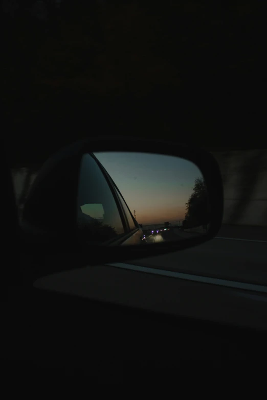 the reflection of lights in a car's side view mirror