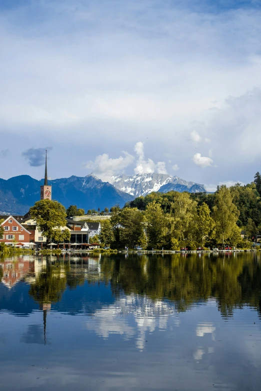 a boat traveling down the lake with mountains in the distance