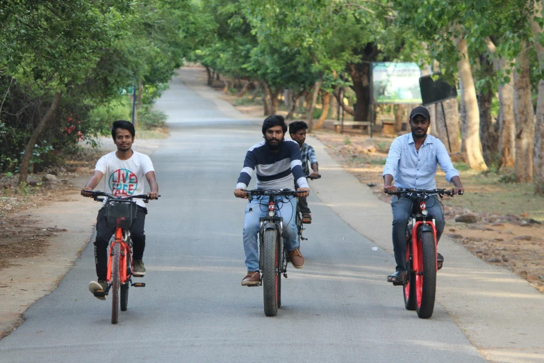 three people on bicycles and one man riding