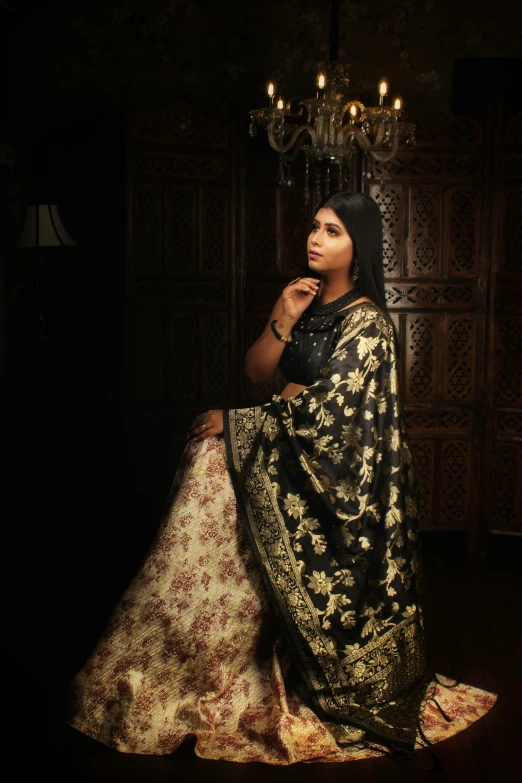 a woman is sitting in a room in a very fancy indian outfit