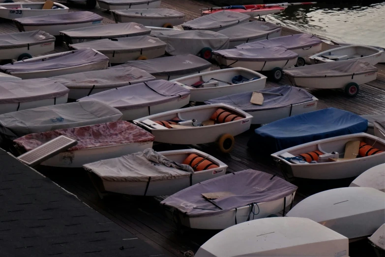 several boats with cover are parked on the dock