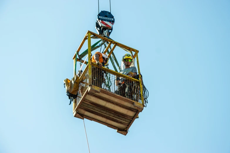 two people are perched in a tower crane