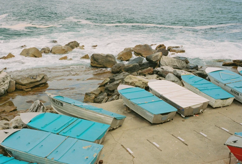 many small boats are lined up on the shore