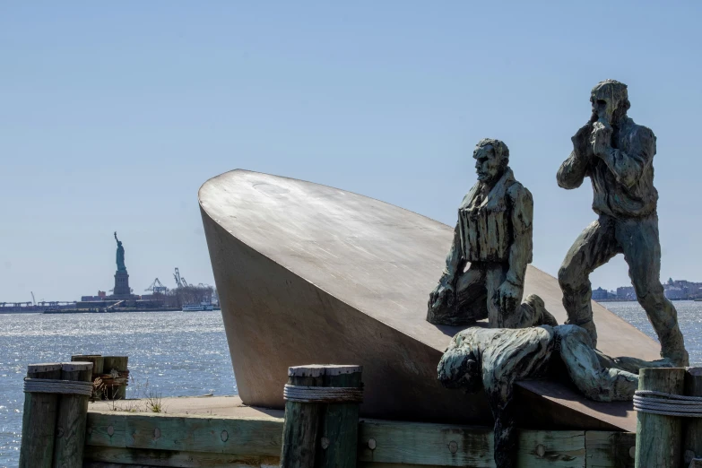 a statue depicting two people standing by the water