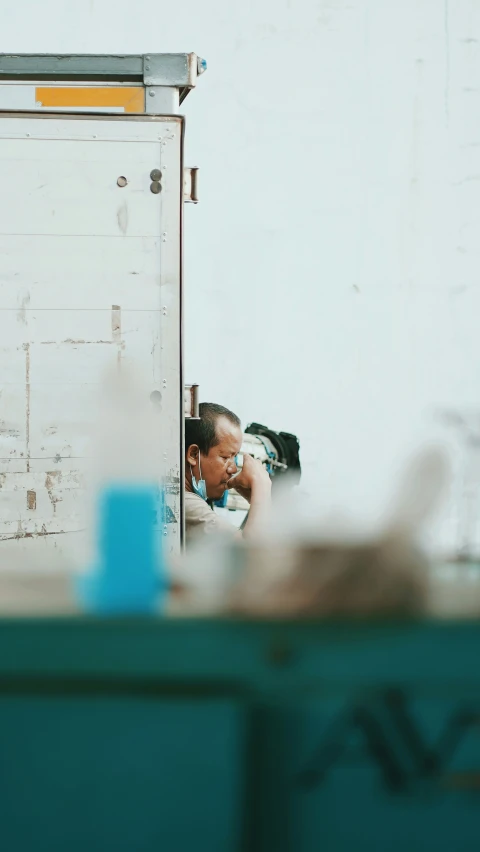 a person sitting next to a truck looking in the mirror