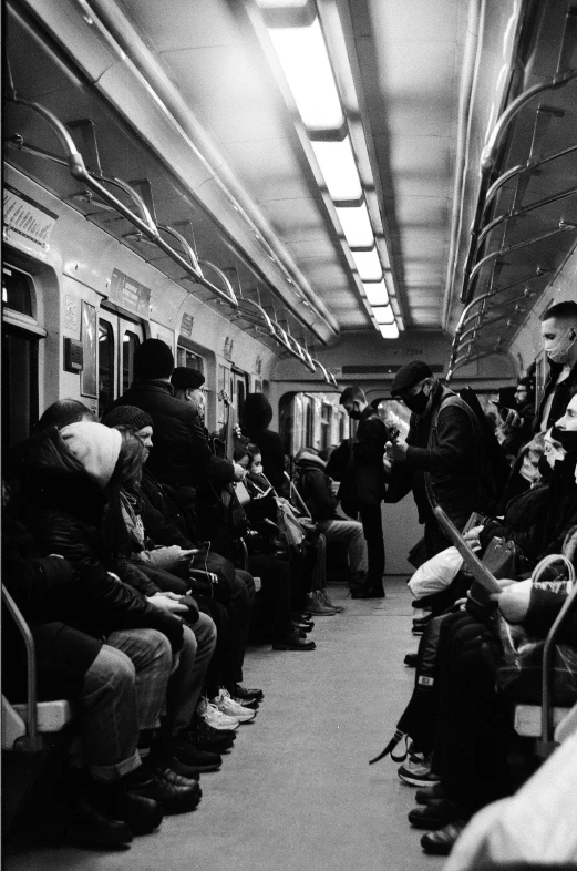 many people sit in the passenger car of an empty subway train