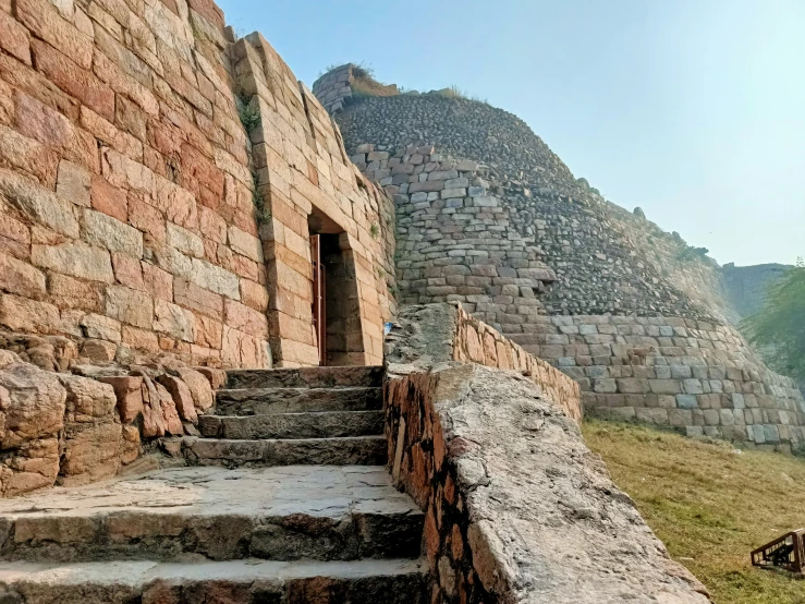 a stone stairway leading to a very old wall