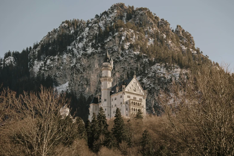 a very old castle sitting on a mountain side